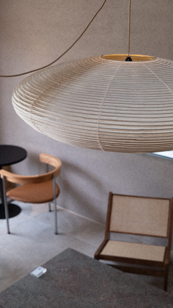Chairs and tables beneath a washi paper lamp
