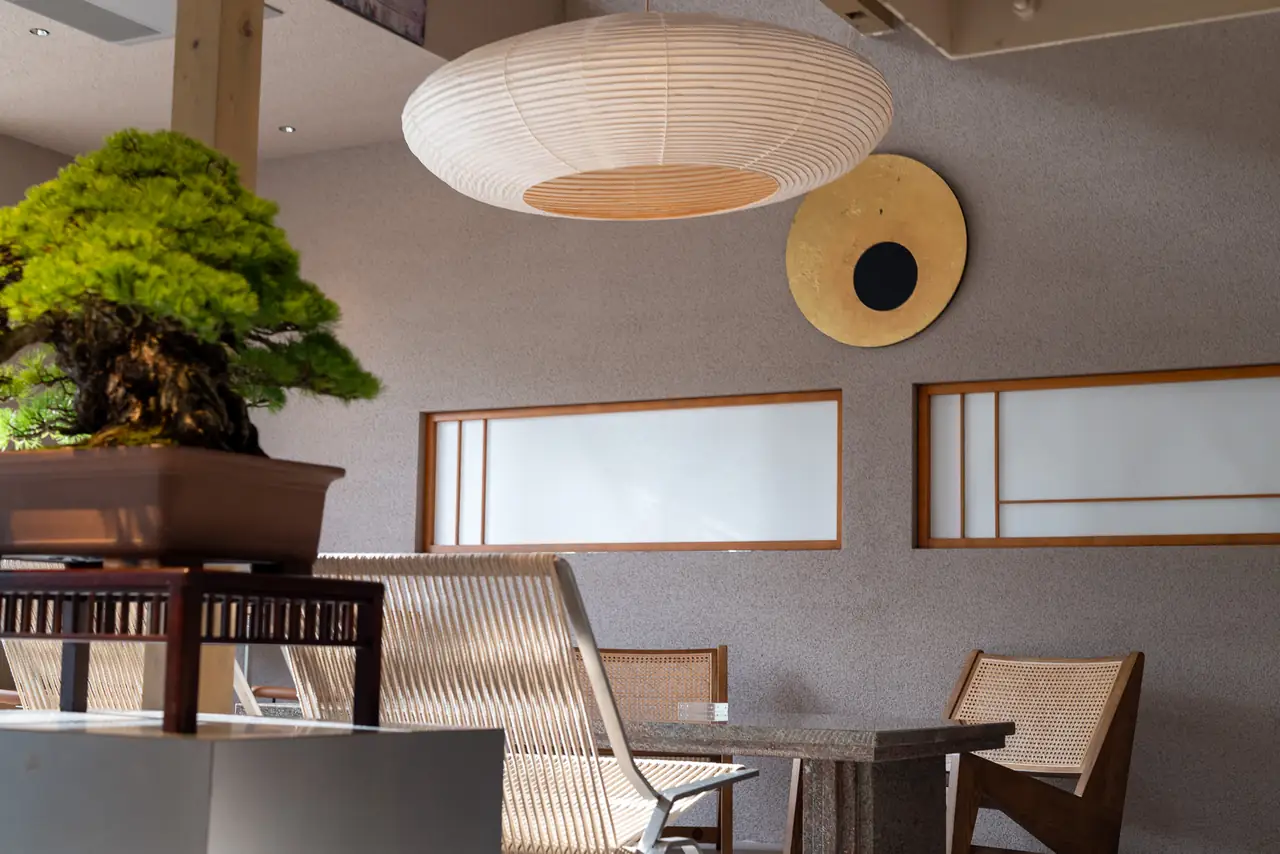 Work by 林宜蓁 hung on the wall beneath a washi paper lamp