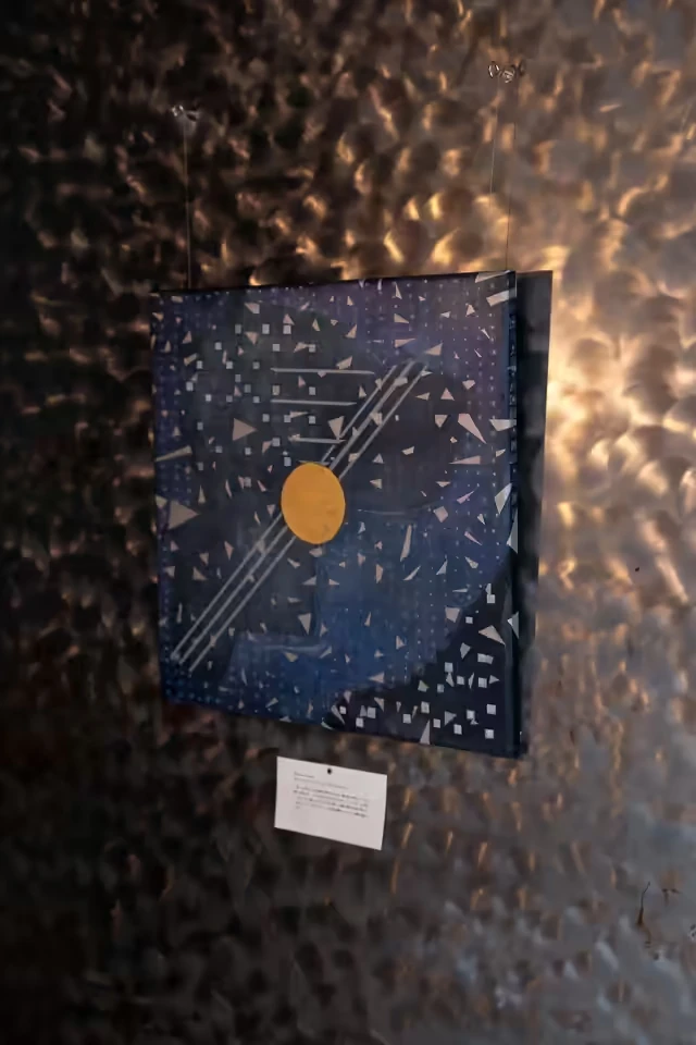 群青の画面に金の円と幾何学の欠片が散る林宜蓁の作品